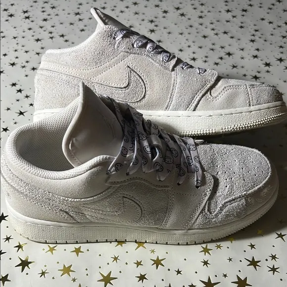 Nike Jordan 1 Low craft series (white) with smiley face shoelaces.