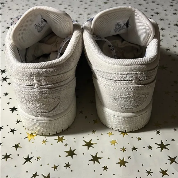 Nike Jordan 1 Low craft series (white) with smiley face shoelaces.
