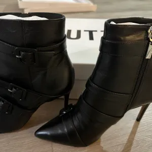 These boots are sleek black leather ankle boots by Schutz.